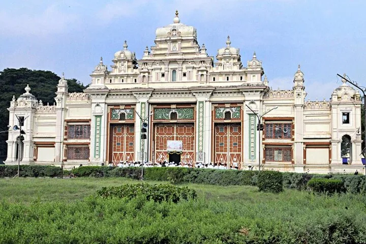 Ornate white facade of Jaganmohan Palace with people gathered near the entrance.